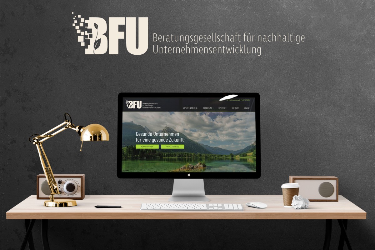 Die Startseite der BFU GmbH auf einem PC-Monitor auf einem Schreibtisch