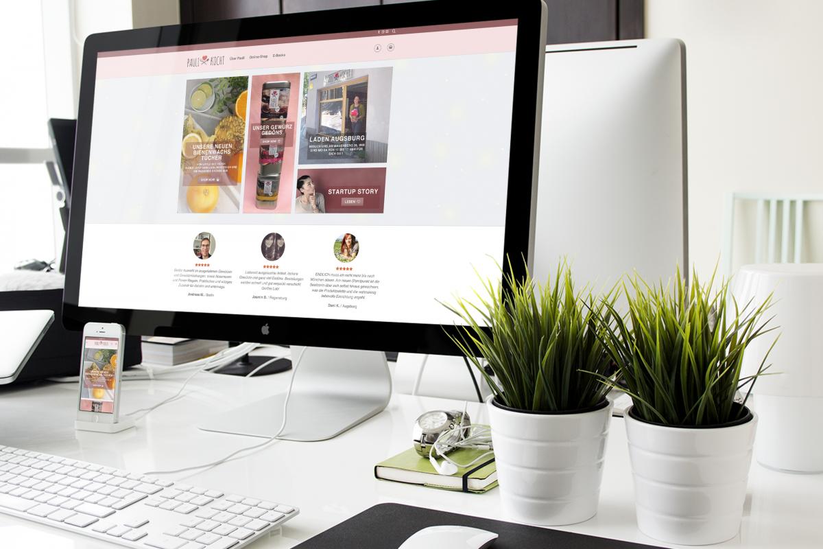 Die Webseite von Paulikocht auf einem PC-Monitor und einem Handy auf einem Schreibtisch